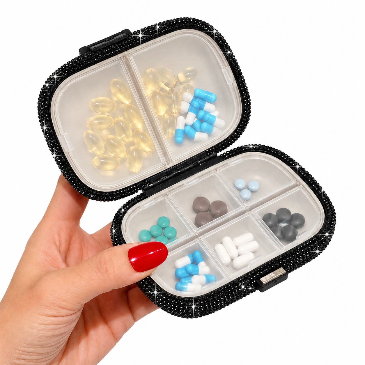 Open black pill organizer held in hand showing divided storage compartments