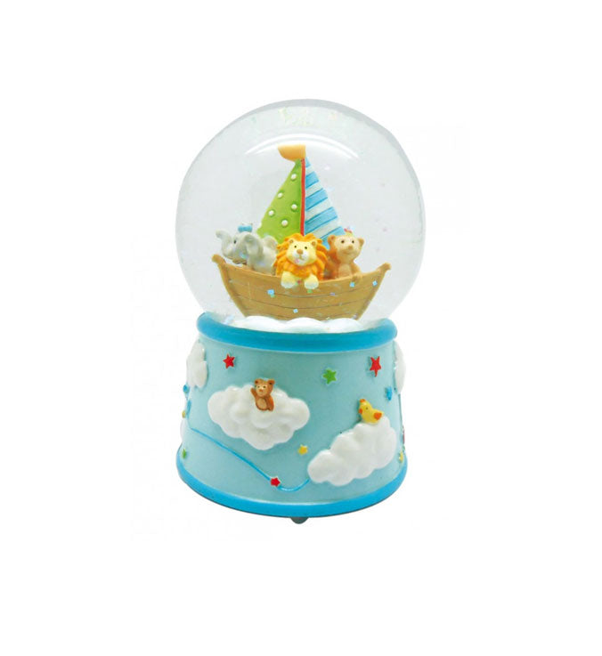 A toy snow globe music box featuring cartoon animals in a sailboat inside a clear globe, set on a light blue base decorated with clouds, stars, and a small duck.