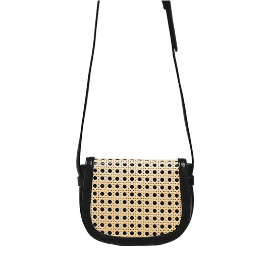 A small shoulder bag with a black leather trim and strap, featuring a natural woven cane or rattan front panel with a black circular dot pattern, shown against a plain white background.