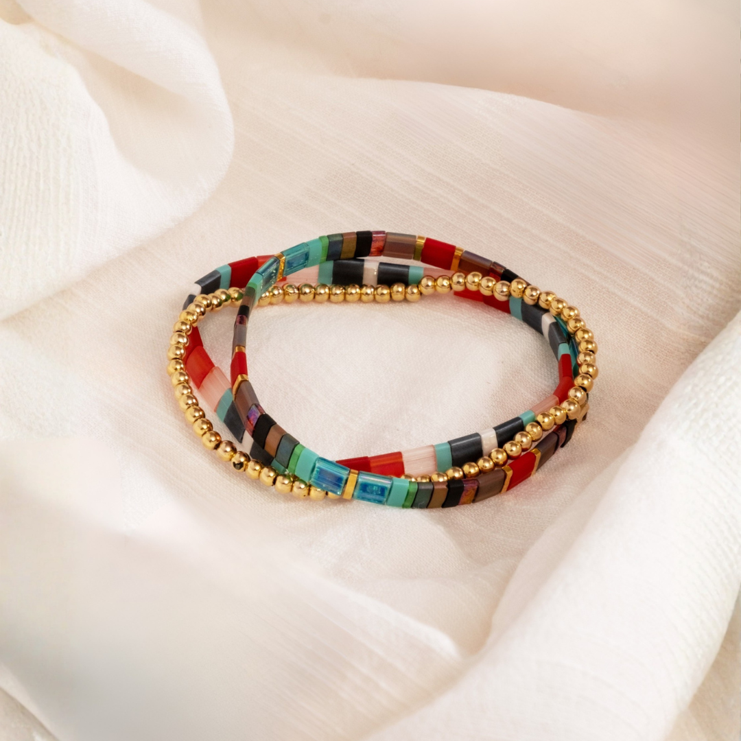 Multicolored beaded bracelet with gold accents on a soft beige background