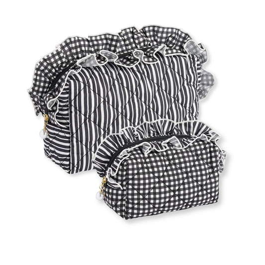 Large and a small quilted bags in a black and white gingham and stripe pattern with ruffled trim, arranged on a white background.
