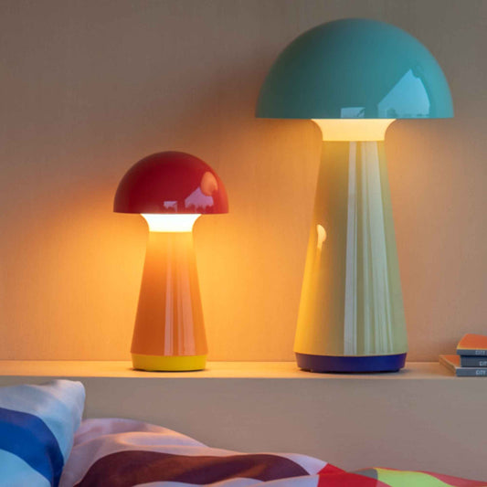 Two colorful mushroom-shaped lamps on a shelf with a soft background.