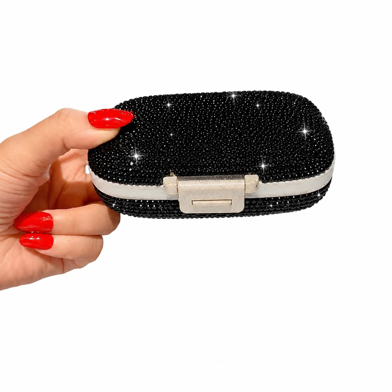 Portable black crystal pillbox held in hand showing compact travel size