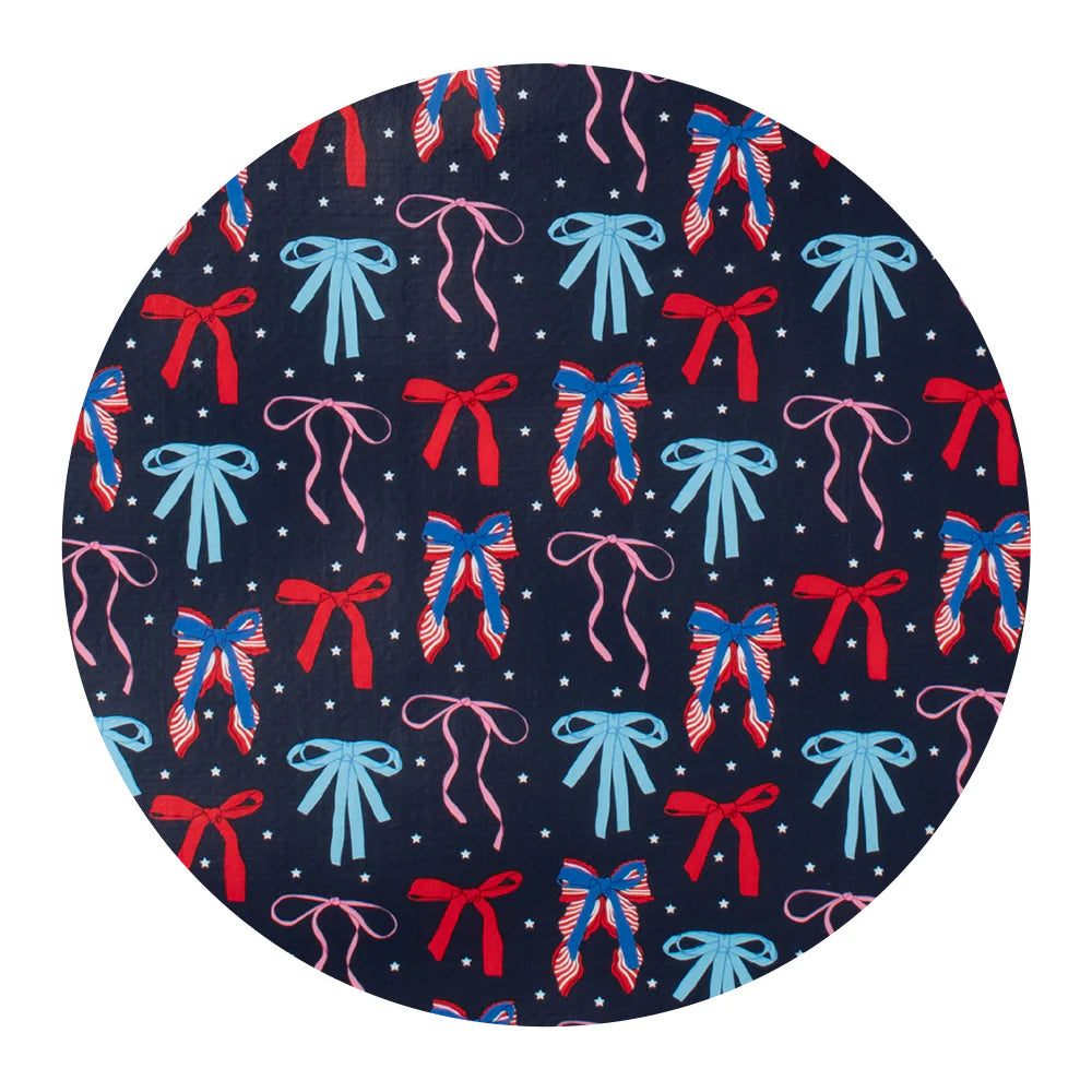 Round swatch with a pattern of colorful bows on a navy background