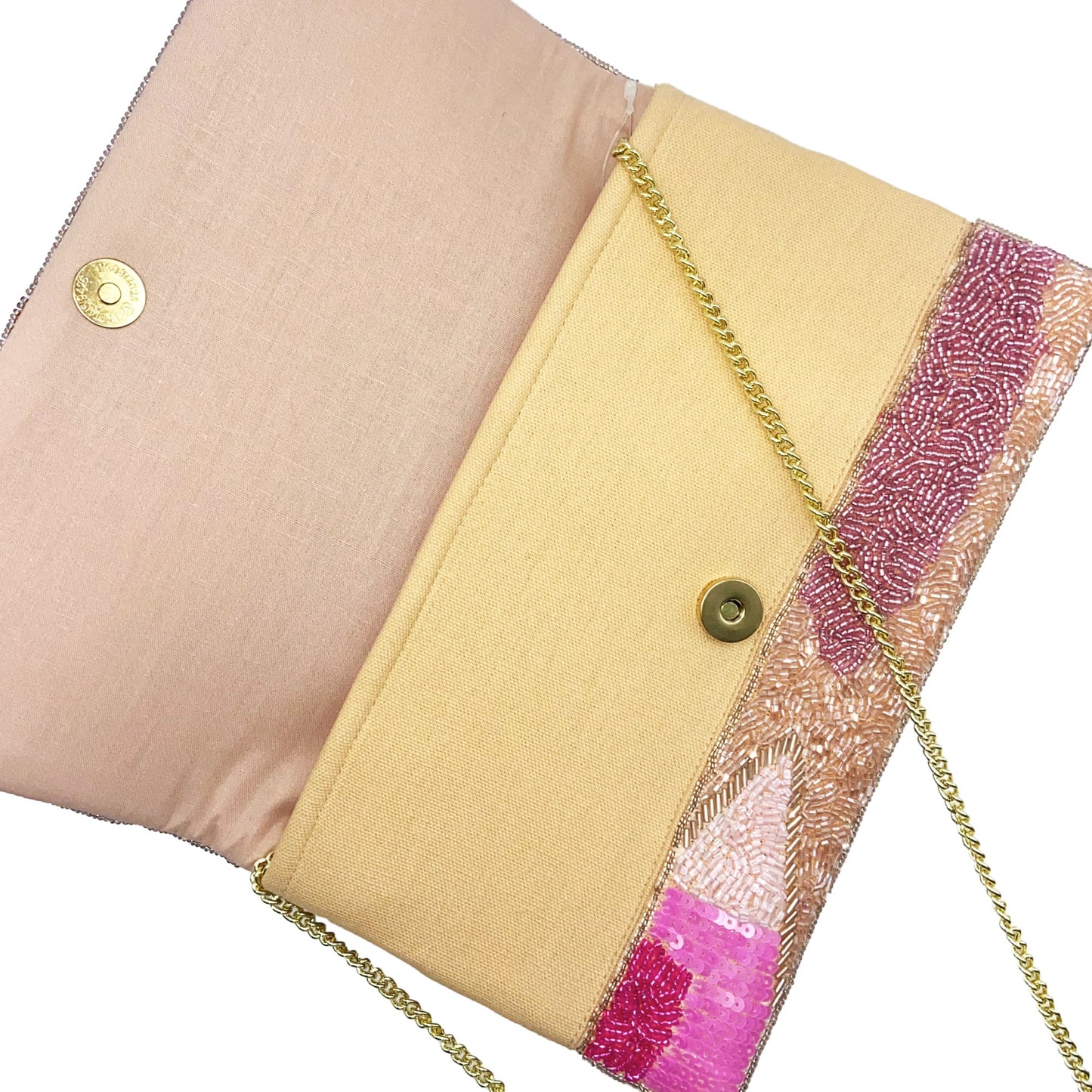 Pink clutch bag with pink abstract pattern and gold chain strap on a white background