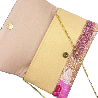 Pink clutch bag with pink abstract pattern and gold chain strap on a white background