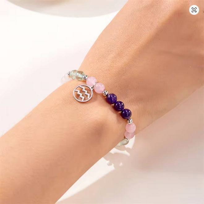 Multicolored beaded Aries bracelet on a wrist with a plain background
