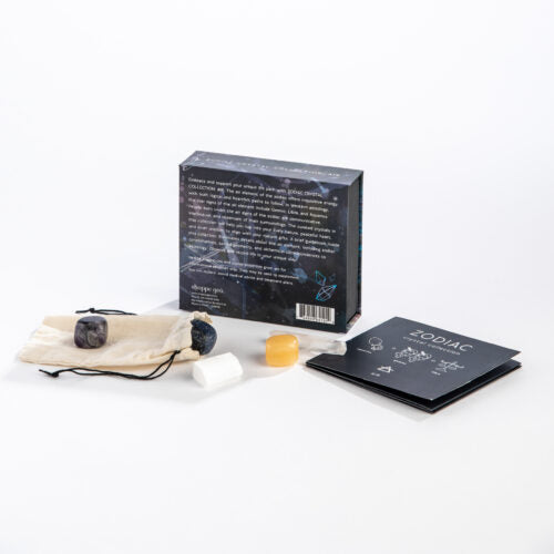 Zodiac-themed product set with cards, stones, and packaging on a white background