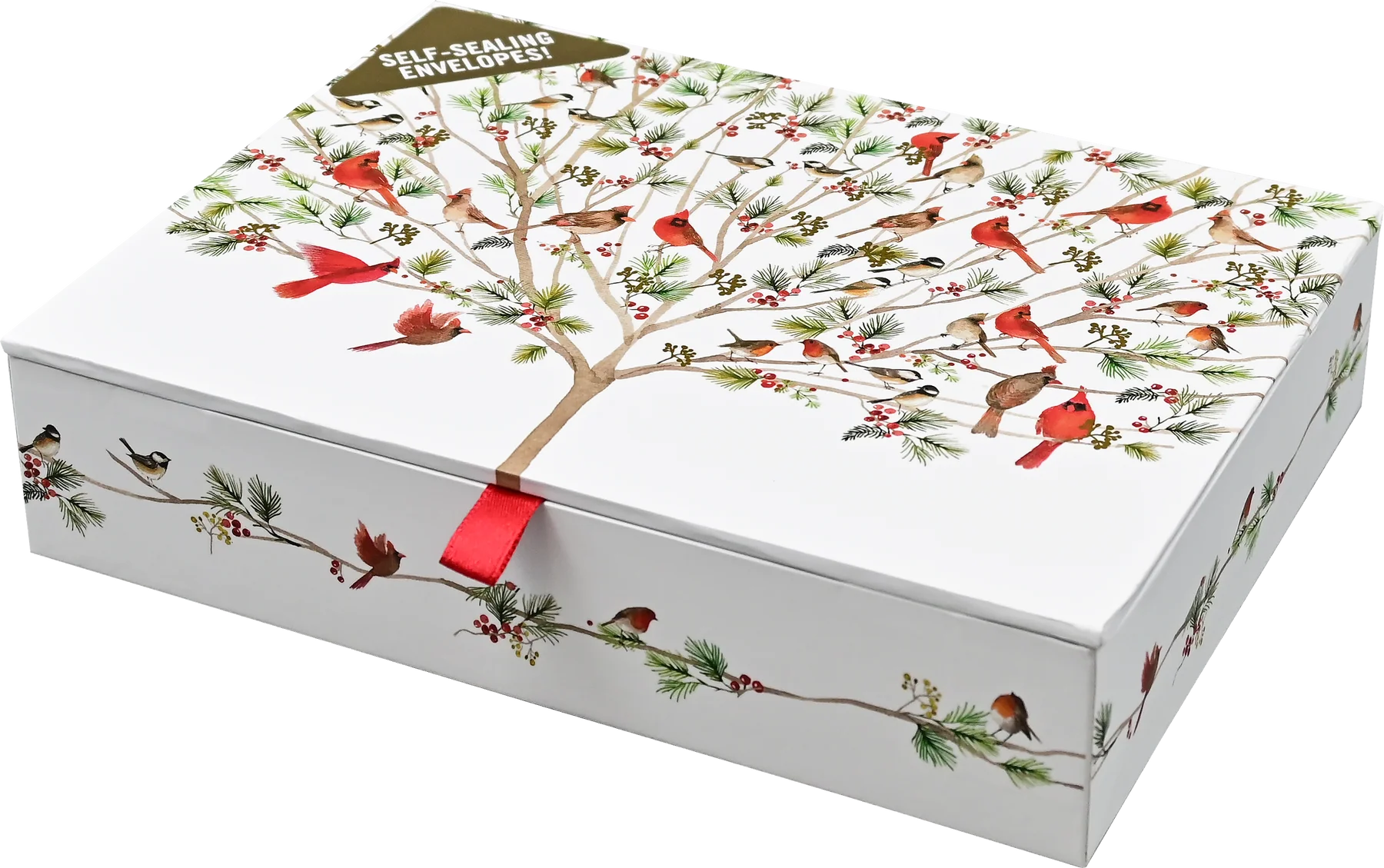 A white rectangular gift box with a lid printed with a winter tree of life design featuring red cardinals, green pine branches, and small birds. A red ribbon tie is visible at the center front, and a small tag at the top reads 'SELF-ADHESIVE ENVELOPE!'.