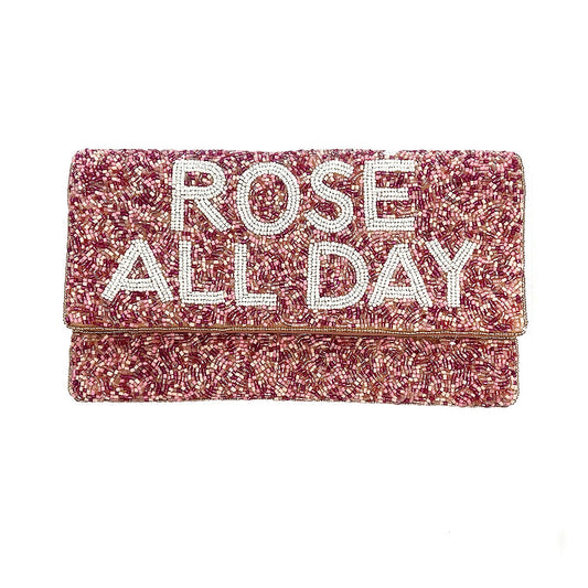 Pink glittery clutch bag with 'Rose All Day' text on a white background