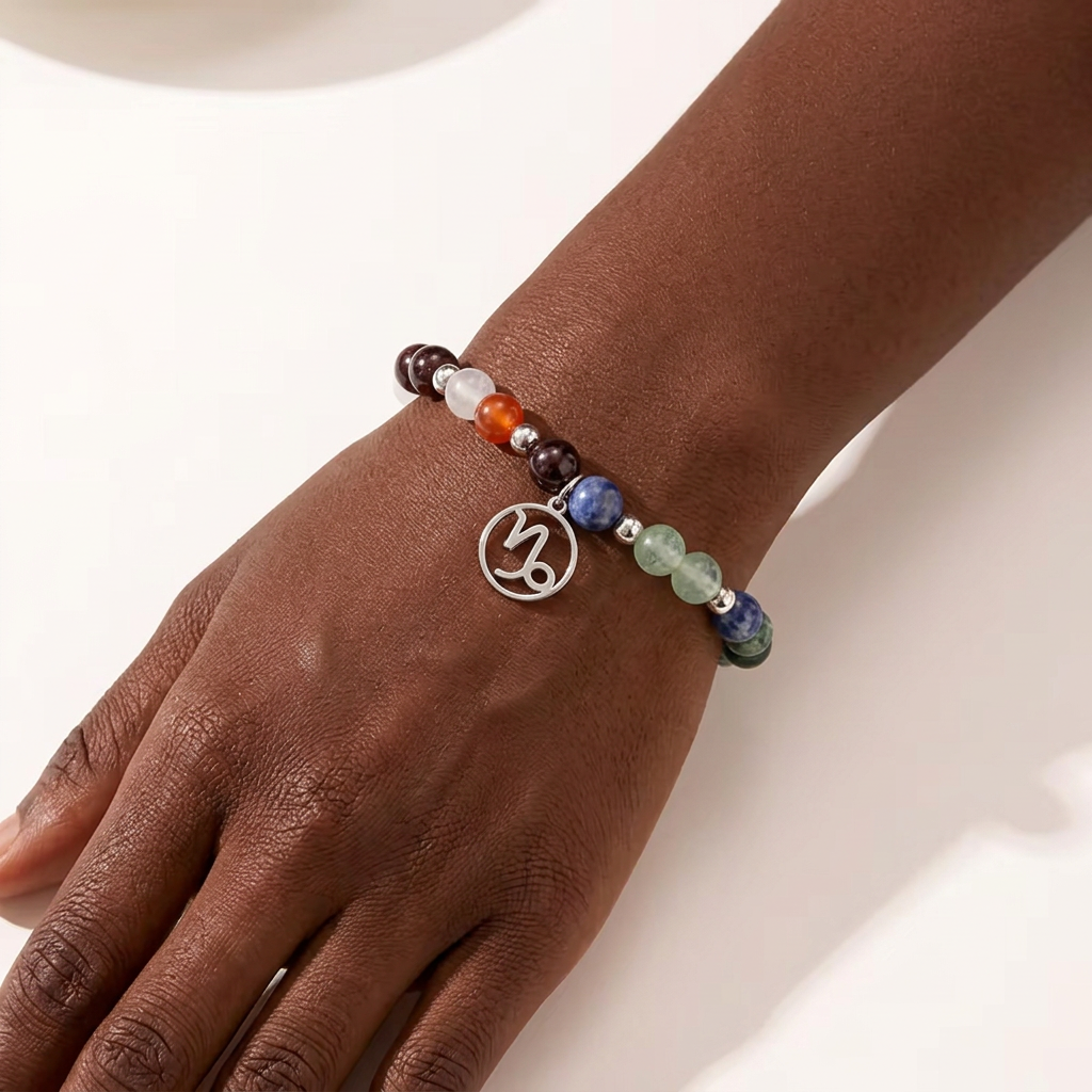 Bracelet with colorful beads and a silver charm on a wrist against a white background