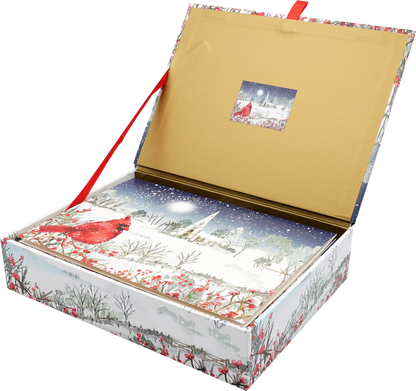 Card box with a cardinal perches on snow- and berry-laden branches, with a country church in the distance. 