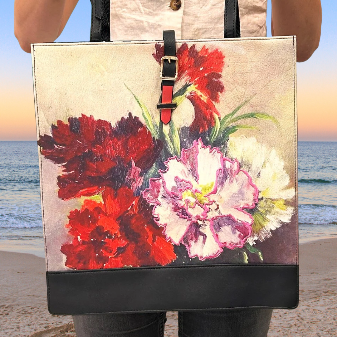 Tote bag with floral design held by a person on a beach