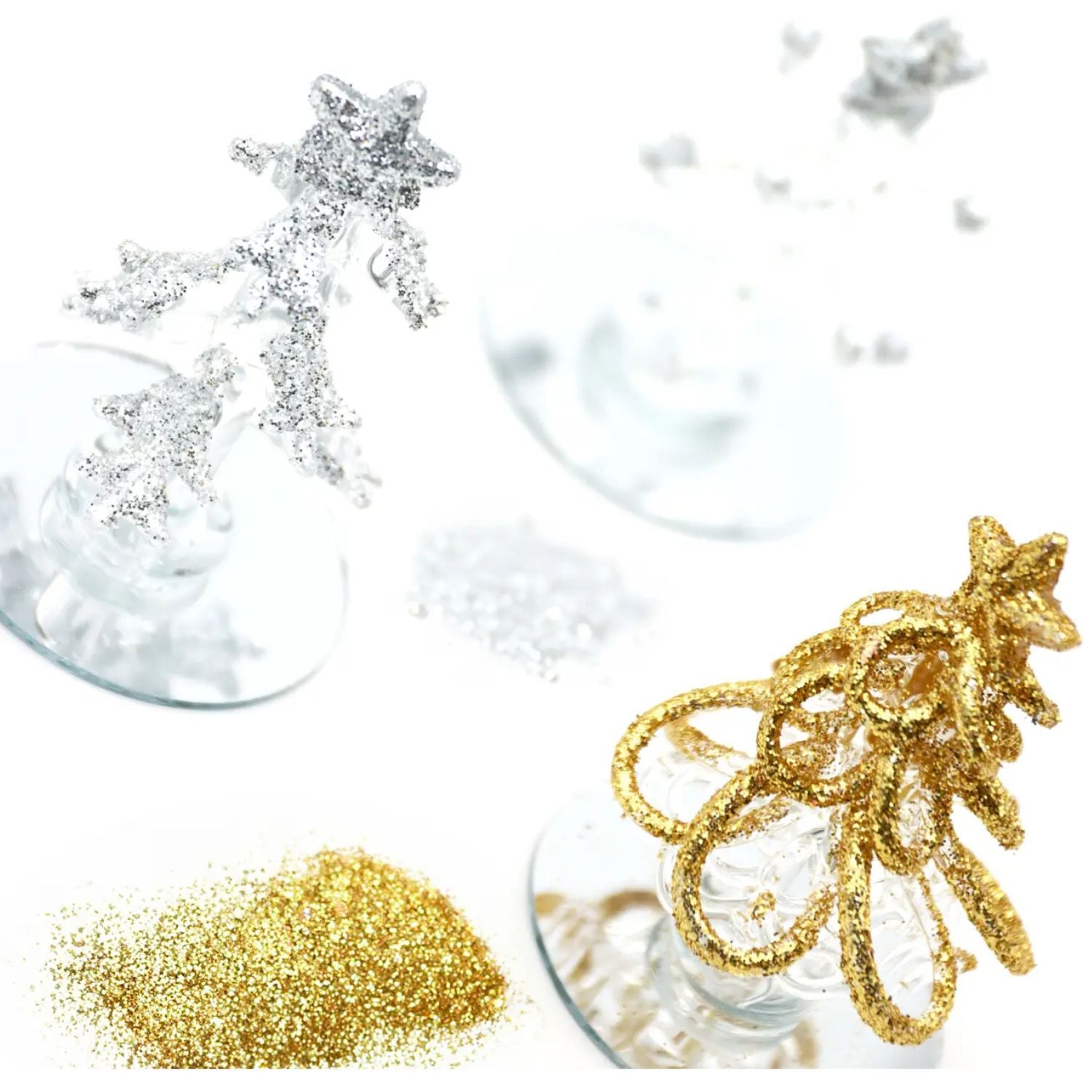 Decorative tree-shaped glass ornaments in gold, silver, and clear on a white background.