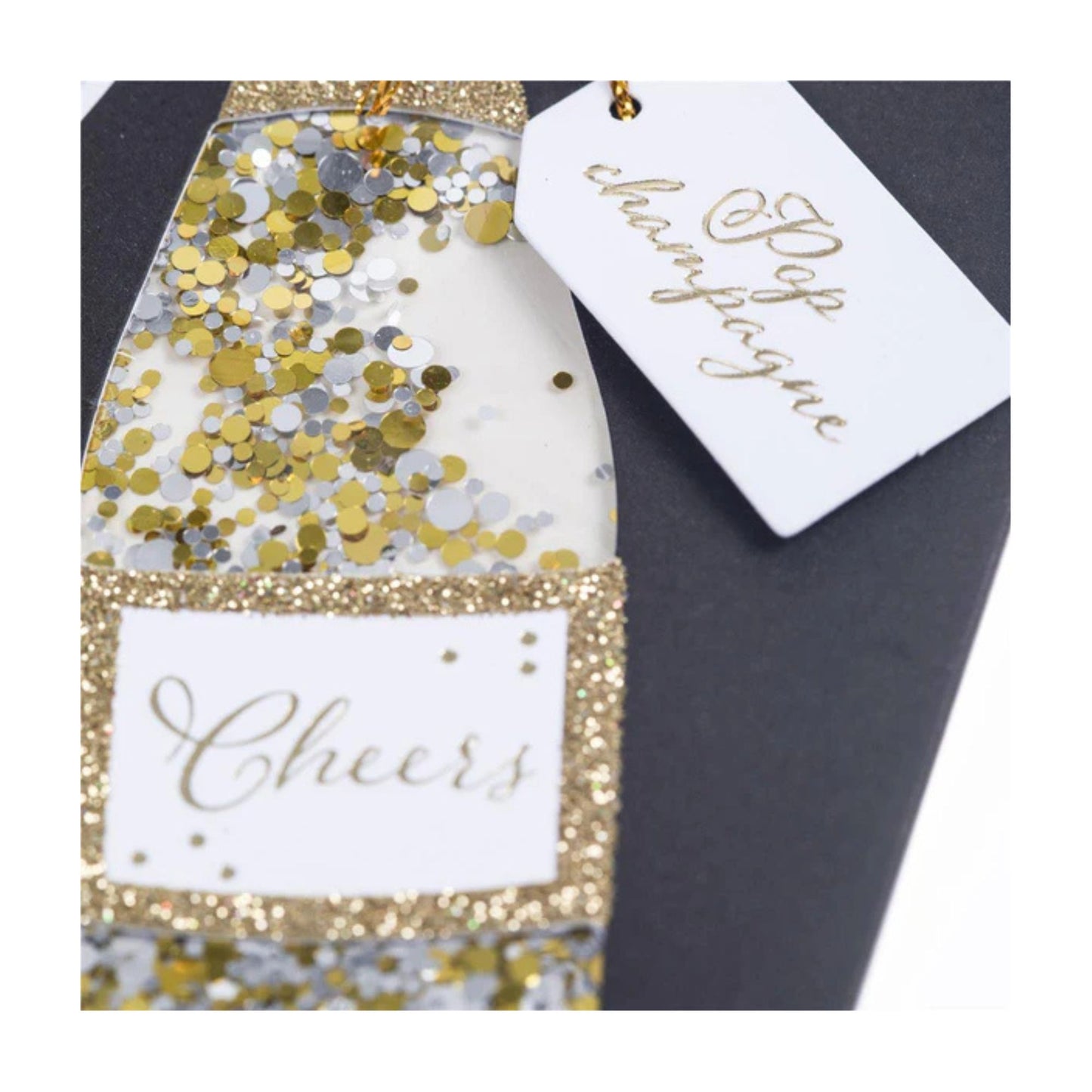 Decorative bottle with gold and silver confetti and 'Cheers' tag on a dark background