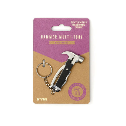 A hammer multi-tool keychain in its original retail packaging. The keychain features a silver stainless steel claw hammer head and a black handle, attached to a split keyring.