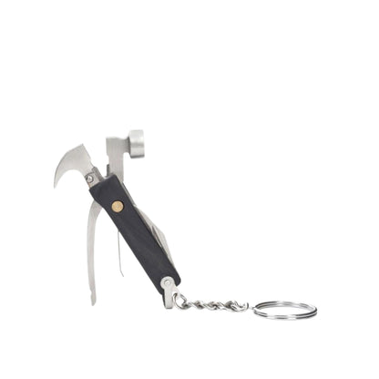 A compact multi-tool keychain with a black handle, silver metal tools including a small hammer, bottle opener, and wire wheel, attached to a split key ring on a plain white background.