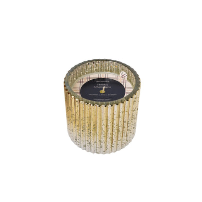 Decorative holiday champagne candle with gold ribbed design on a white background