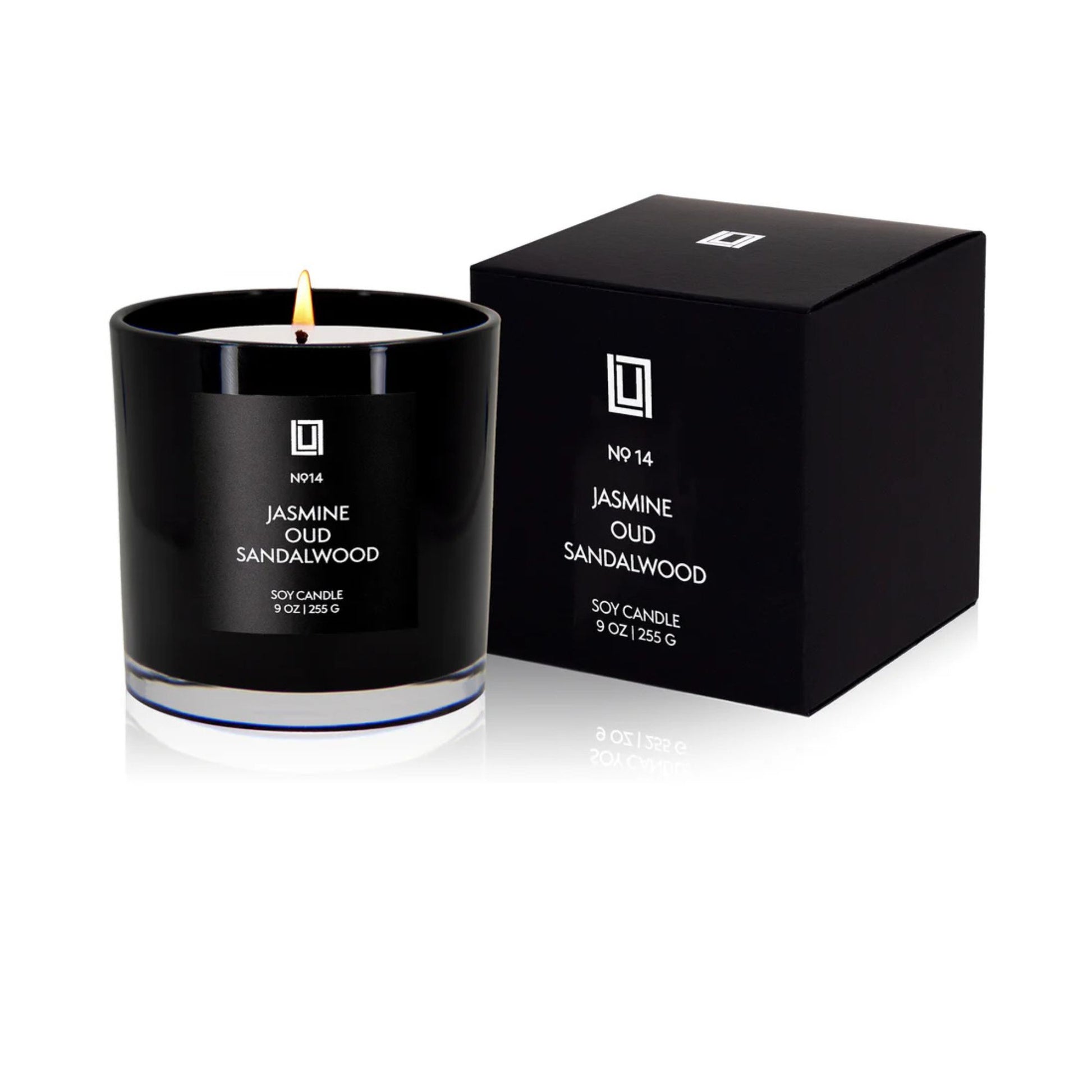 Black candle with Jasmine Oud Sandalwood scent next to its packaging on a white background