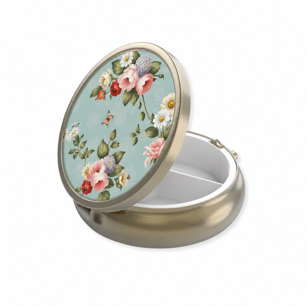 Open round light blue floral pillbox with floral lid, a mirror and divided storage compartments