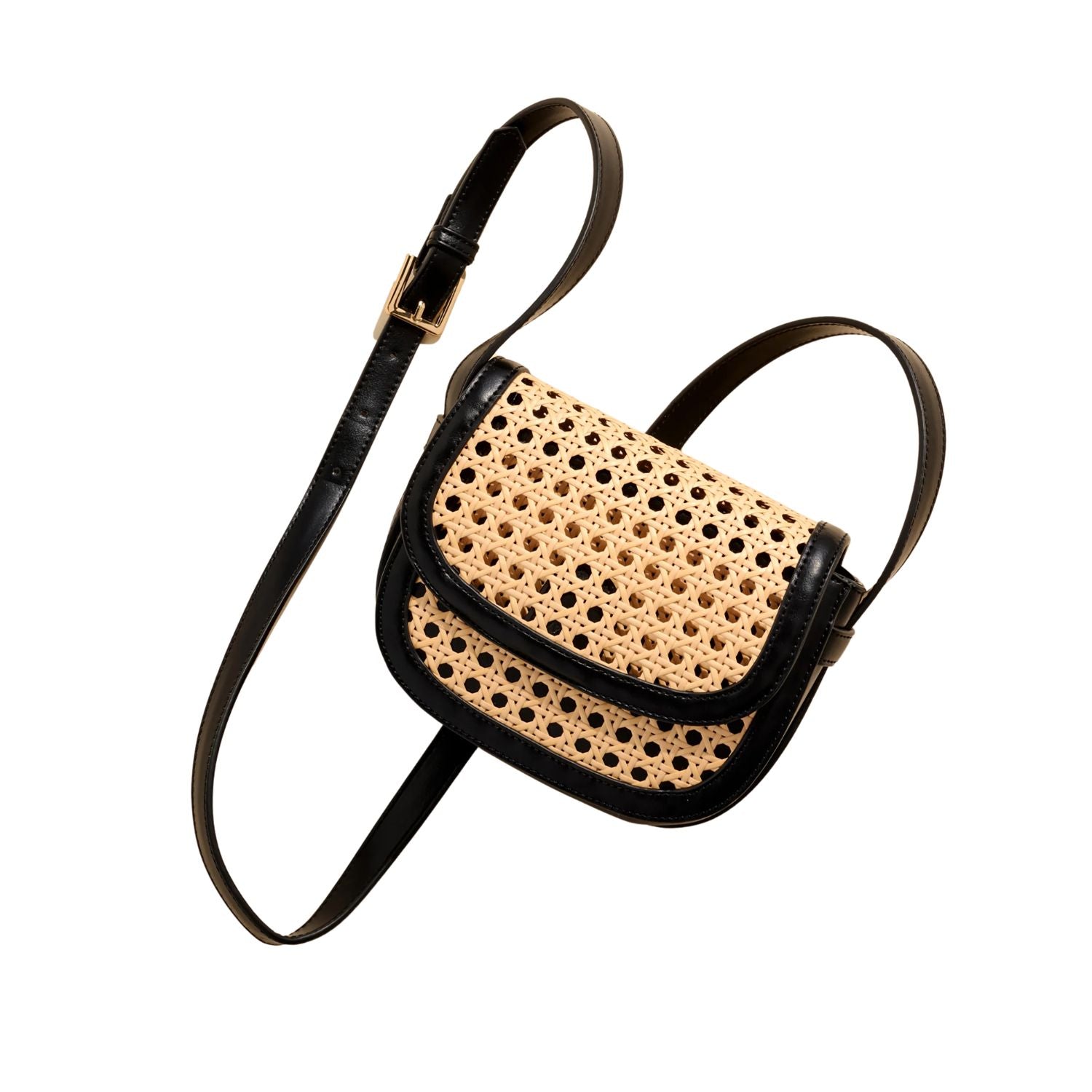 A small crossbody bag with a natural woven cane body and black leather trim, featuring a black adjustable strap with a gold buckle.