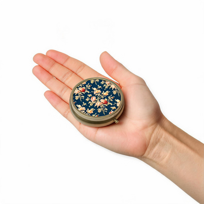 Round dark blue floral pillbox shown in hand to demonstrate compact travel size