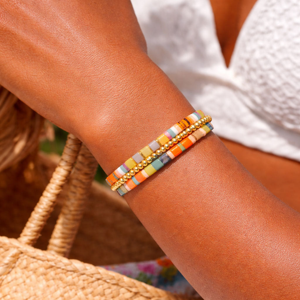 Multicolored beaded bracelet on a wrist with a blurred background
