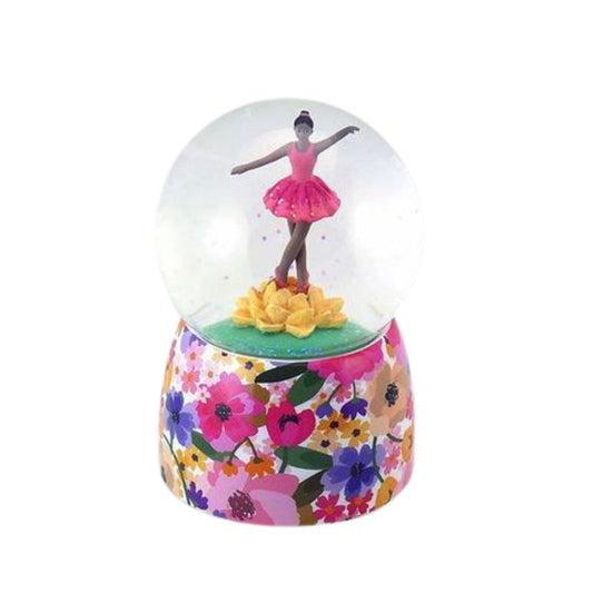 Glowing snow globe with a dancer figure and floral base on a white background