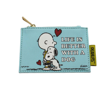 A light blue faux-leather coin purse featuring a Peanuts print of Charlie Brown and Snoopy hugging, with the text 'LIFE IS BETTER WITH A DOG' and a yellow Peanuts brand tag on the side.