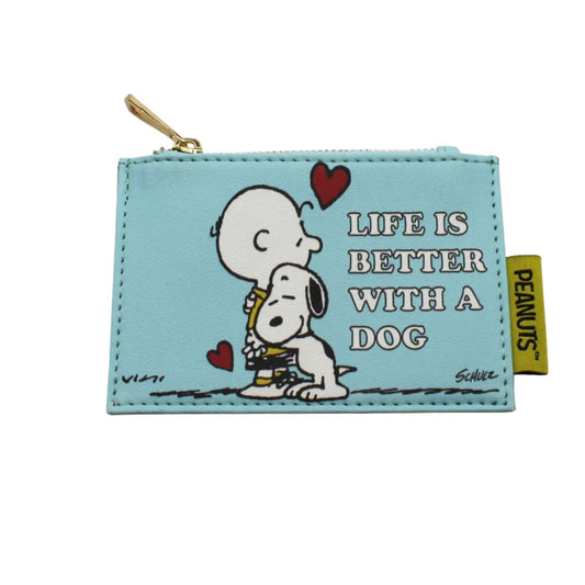 A light blue faux-leather coin purse featuring a Peanuts print of Charlie Brown and Snoopy hugging, with the text 'LIFE IS BETTER WITH A DOG' and a yellow Peanuts brand tag on the side.