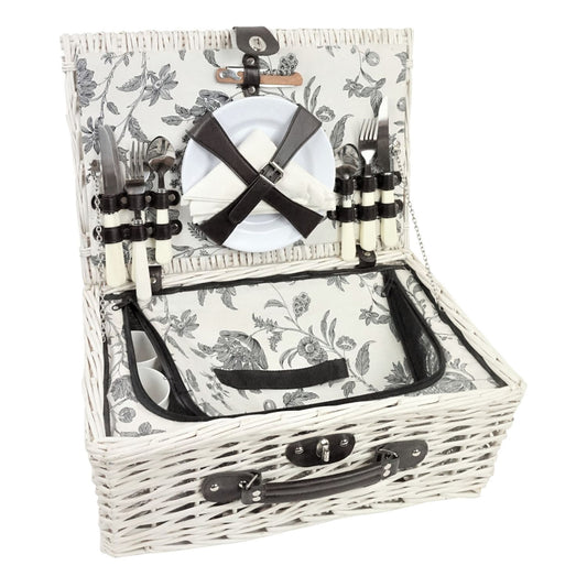 White wicker picnic basket with floral pattern, cutlery, and plates on a white background