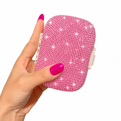 Pink crystal pillbox held in hand with sparkling finish and compact design