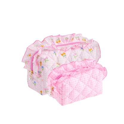 A set of three pink quilted fabric organizer bags with ruffled trim, shown on a plain white background. The set includes a floral print bag, a solid pink bag, and a pink-and-white gingham bag.