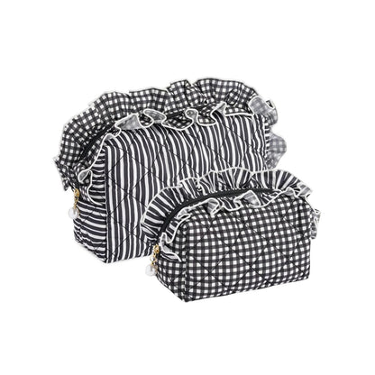 Two quilted cosmetic bags in black and white gingham and striped patterns with ruffled trim, displayed on a white background.