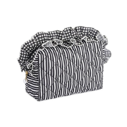 A quilted cosmetic bag with a black and white striped body, a black and white gingham ruffled trim, and a small gold zipper pull, shown on a plain white background.