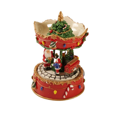 A festive Christmas carousel music box with Santa Claus figures, a decorated tree, candy canes, and a small red train on a white background.