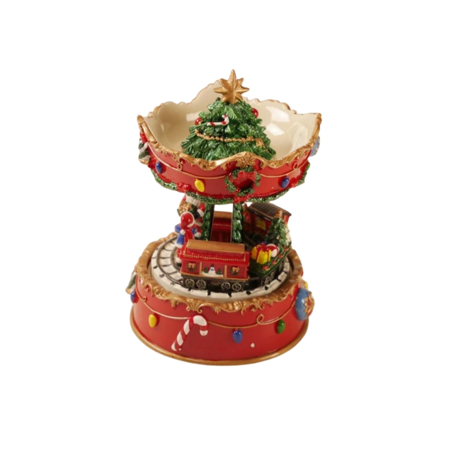 A festive Christmas-themed miniature music box or decorative figurine featuring a red base, a small red train, a decorated green Christmas tree, wreaths, candy canes, and colorful ornaments on a plain white background.
