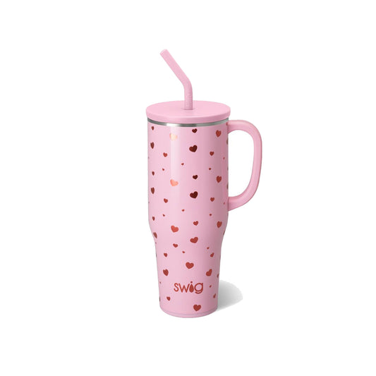 Pink tumbler with heart pattern and straw on a white background