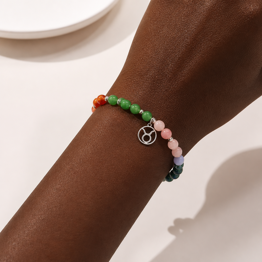 Multicolored beaded bracelet with a silver Taurus charm on a wrist against a neutral background
