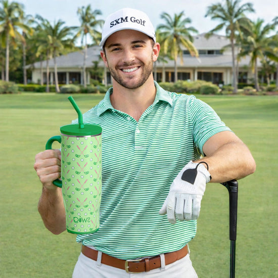 Young man holding a green tumbler with a golf club on a golf course